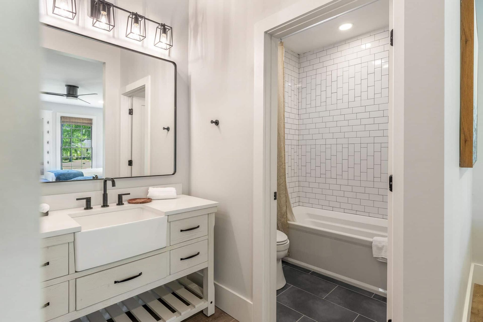 A bathroom with a sink , mirror , toilet and bathtub.
