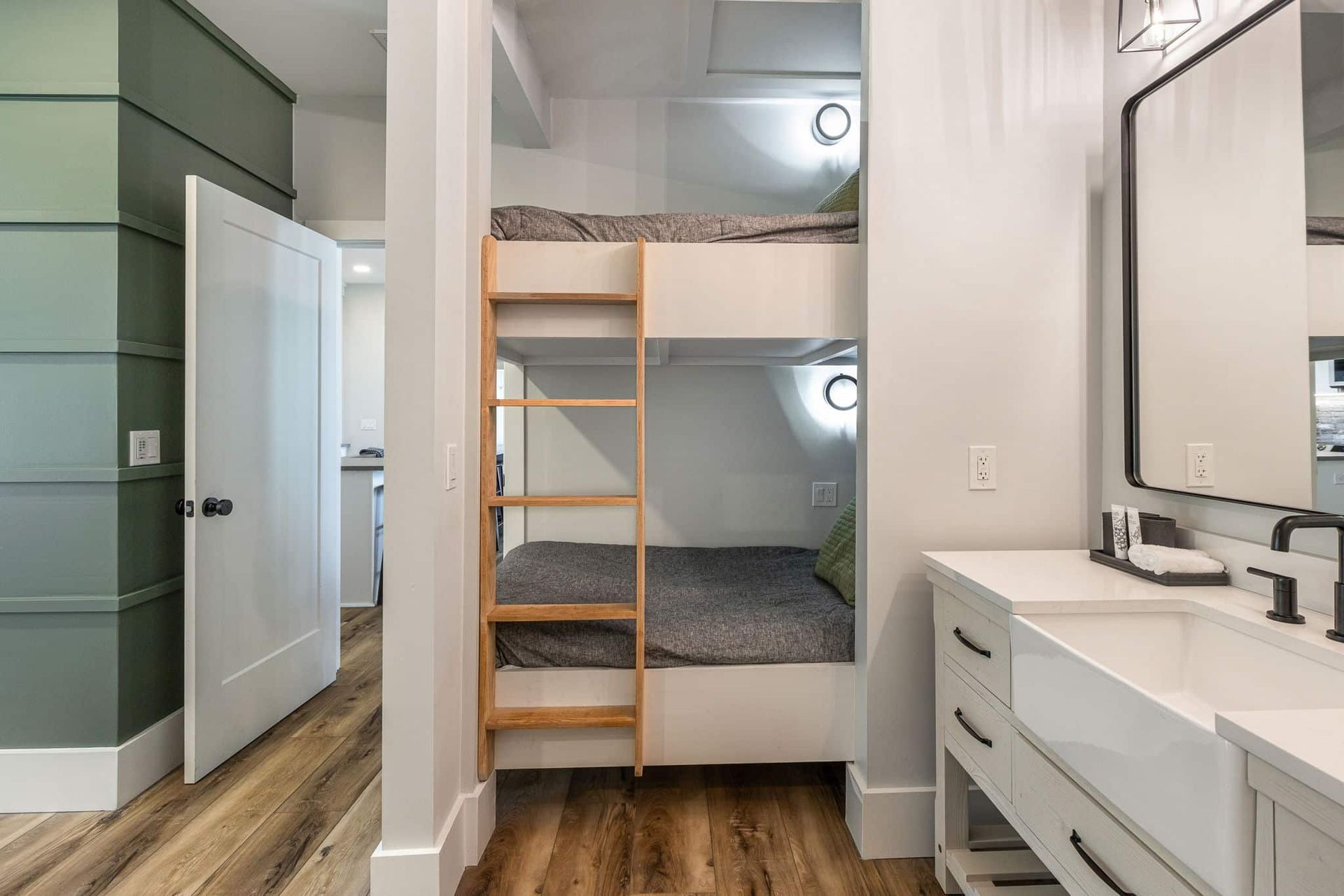A bathroom with a bunk bed and a sink.