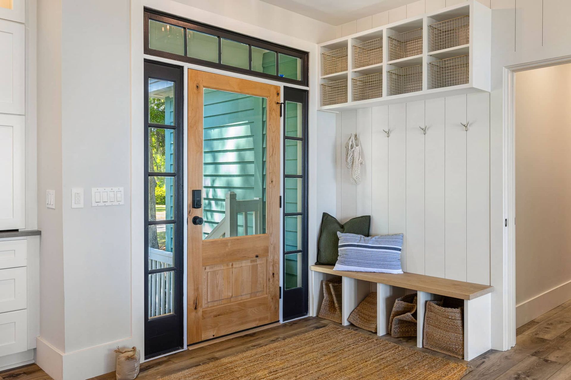 A hallway with a wooden door and a bench in front of it.