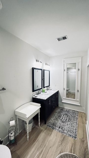 A bathroom with two sinks , a toilet , and a mirror.