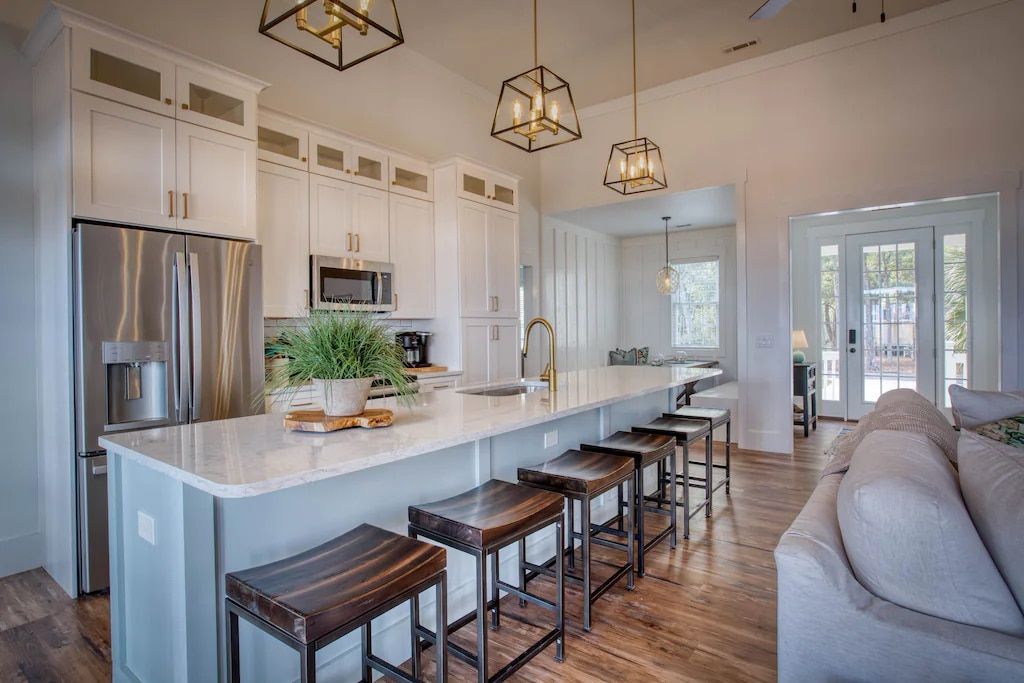 A kitchen with a large island , stools and a couch.