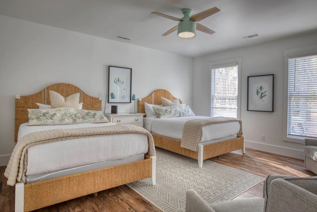 A bedroom with two beds and a ceiling fan.