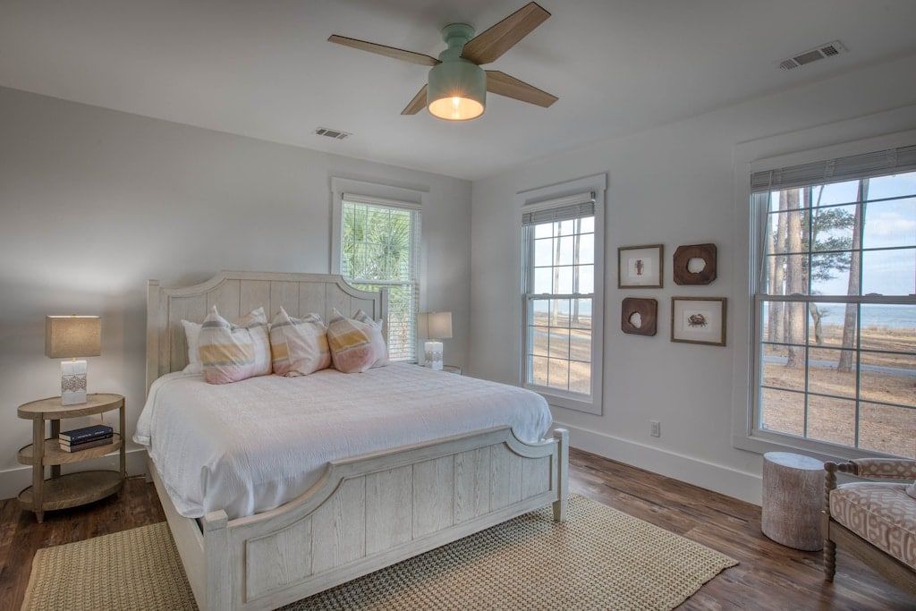A bedroom with a king size bed and a ceiling fan.