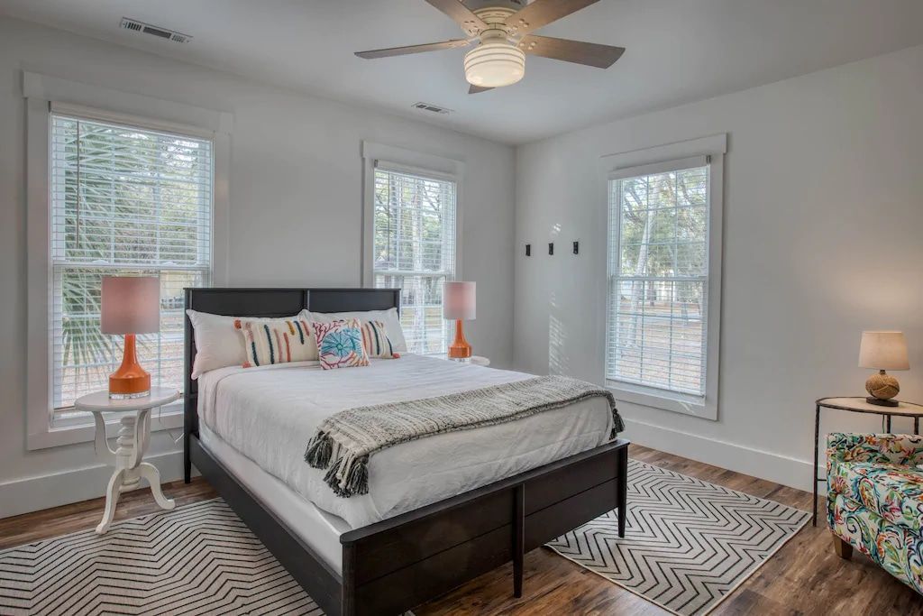 A bedroom with a king size bed and a ceiling fan.