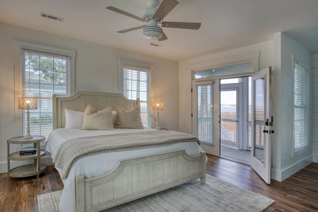 A bedroom with a king size bed and a ceiling fan.