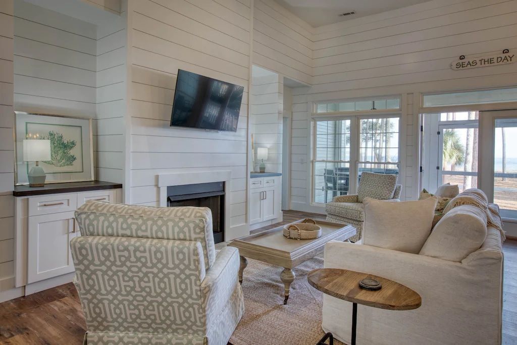 A living room with a couch , chair , table , fireplace and television.