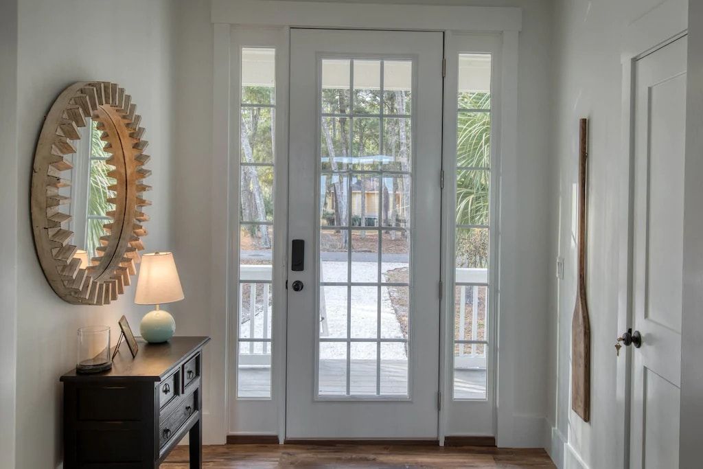 A hallway with a white door and a mirror on the wall.