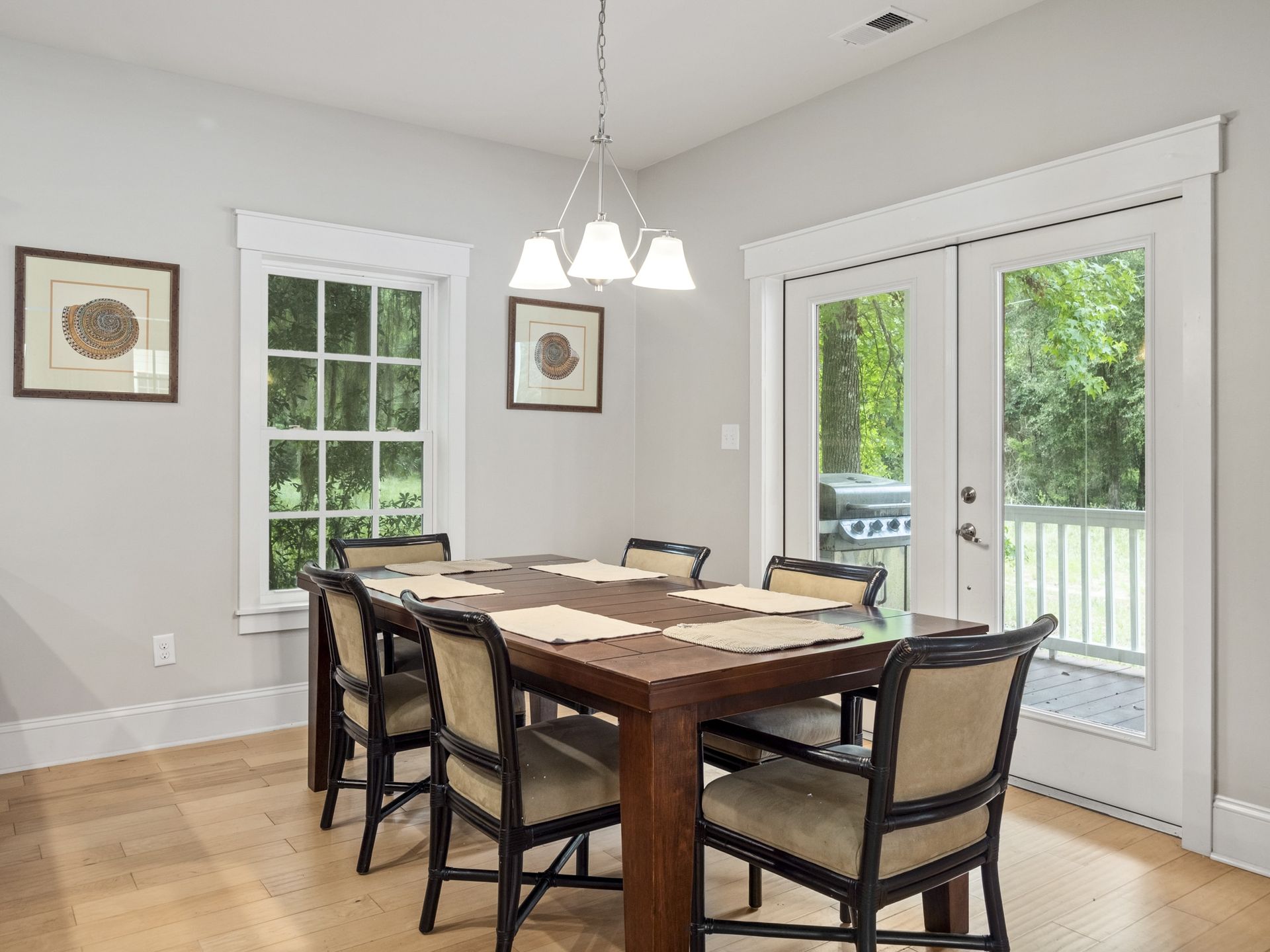 A dining room with a table and chairs and a chandelier.