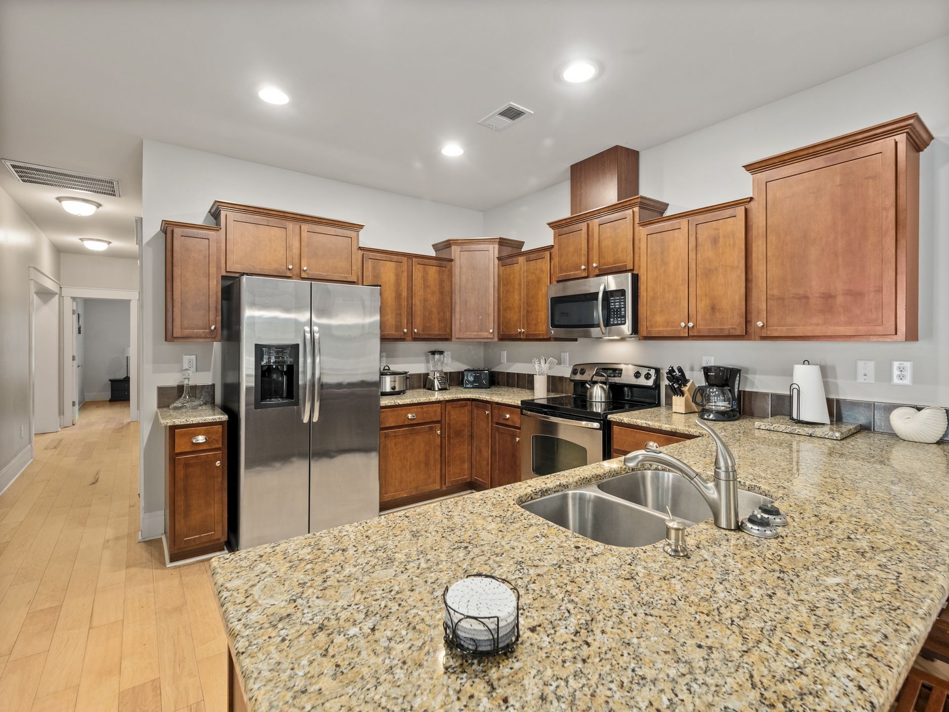 A kitchen with granite counter tops , stainless steel appliances , and wooden cabinets.