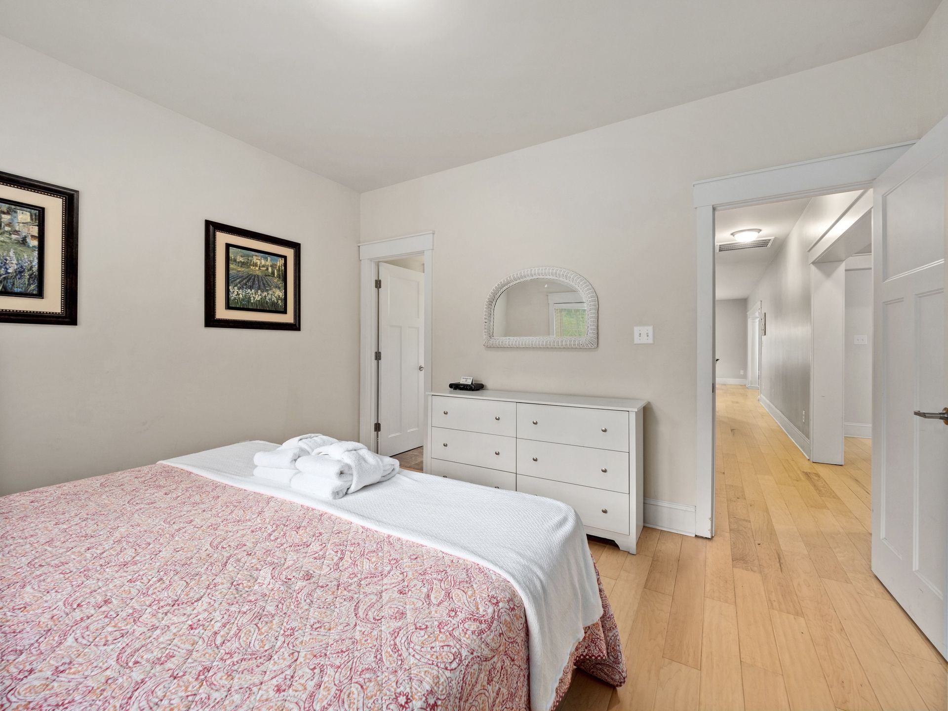 A bedroom with a bed , dresser and mirror.