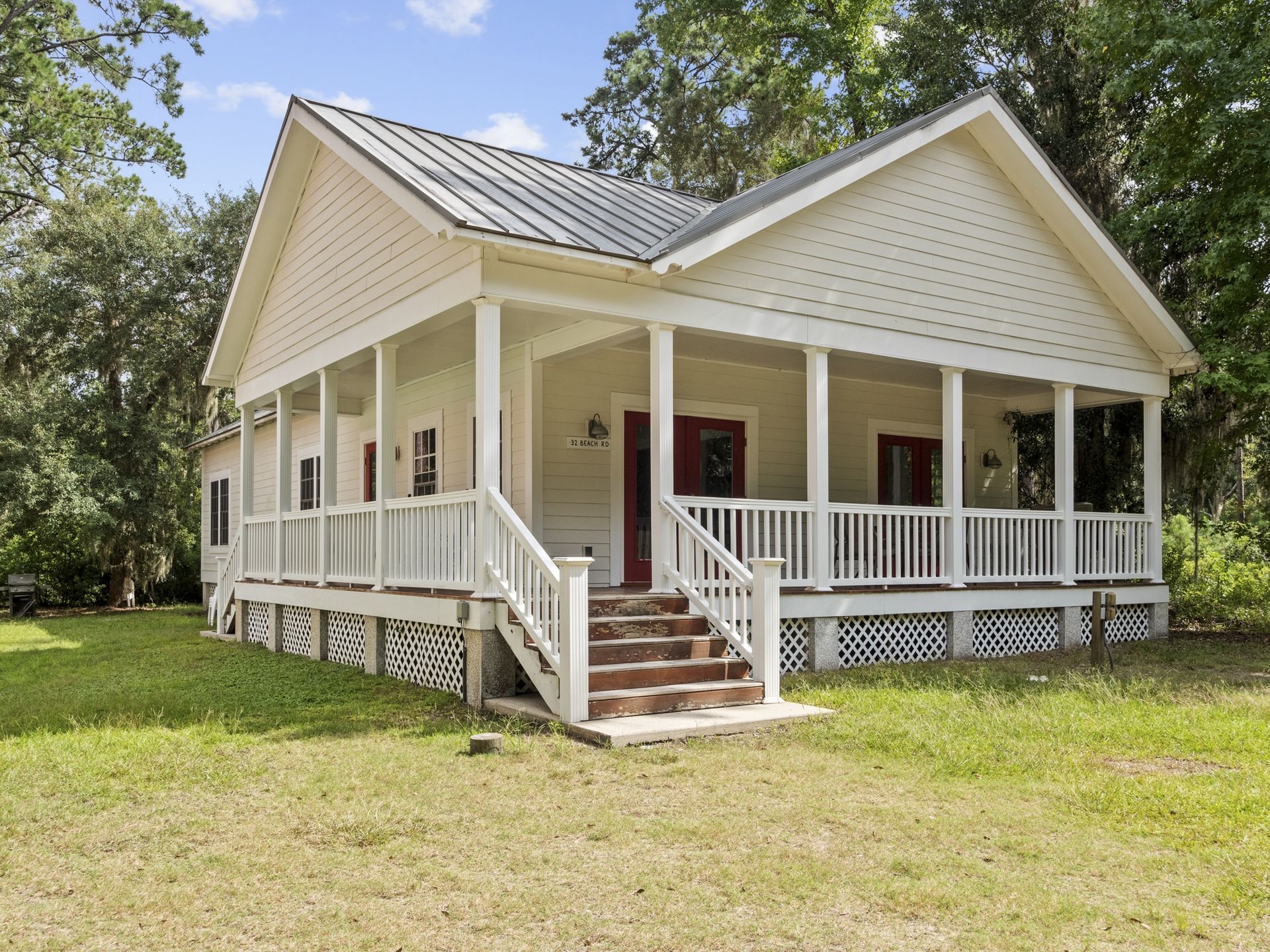 A white house with a large porch and stairs