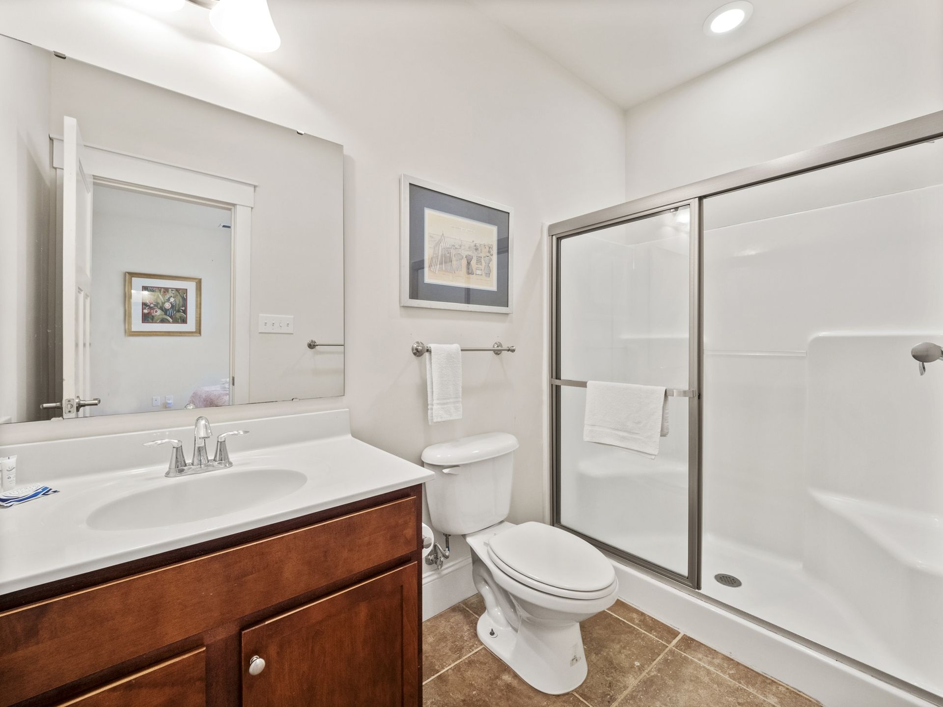 A bathroom with a toilet , sink and shower.