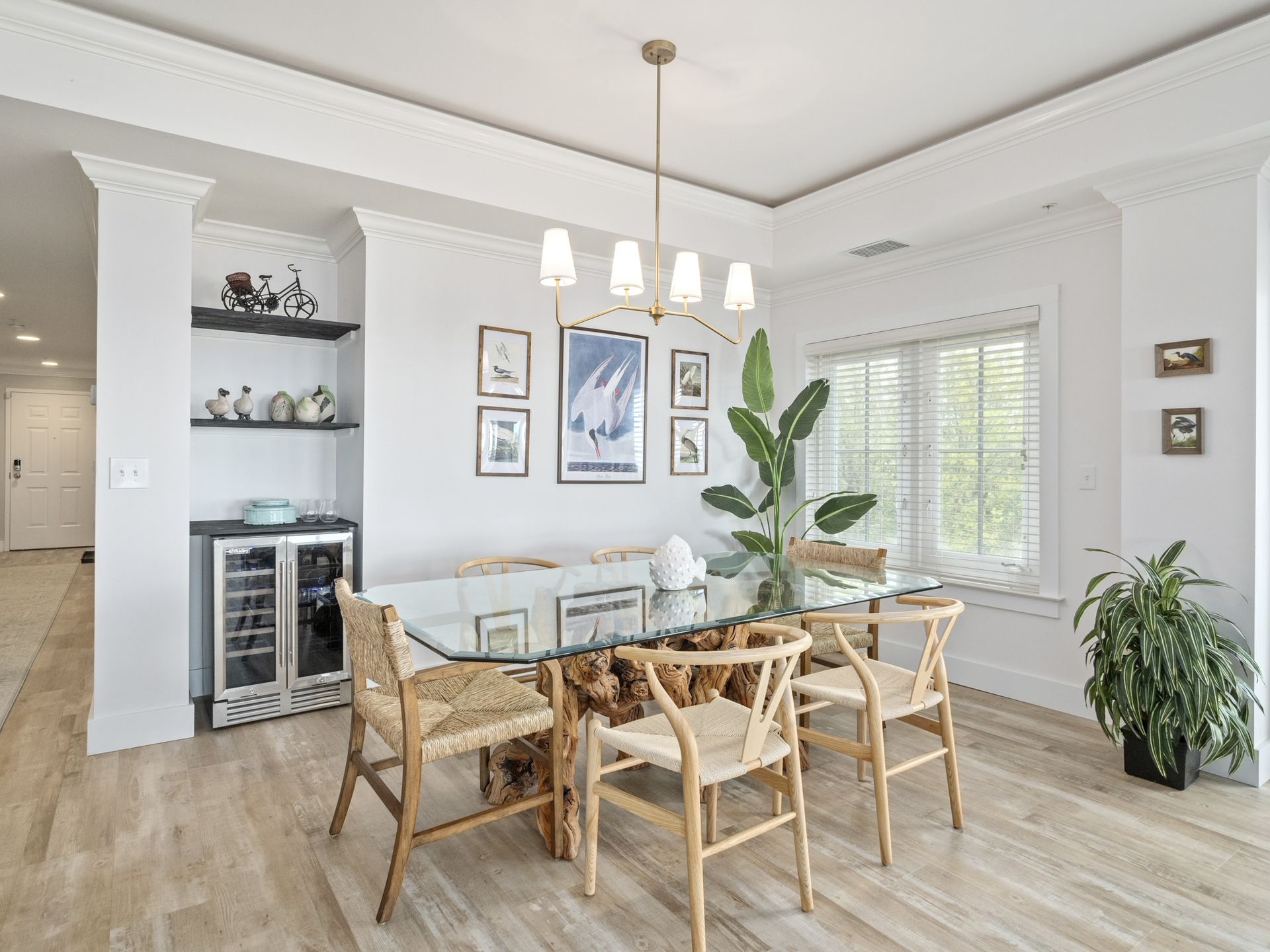 A dining room with a table and chairs and a wine cooler.