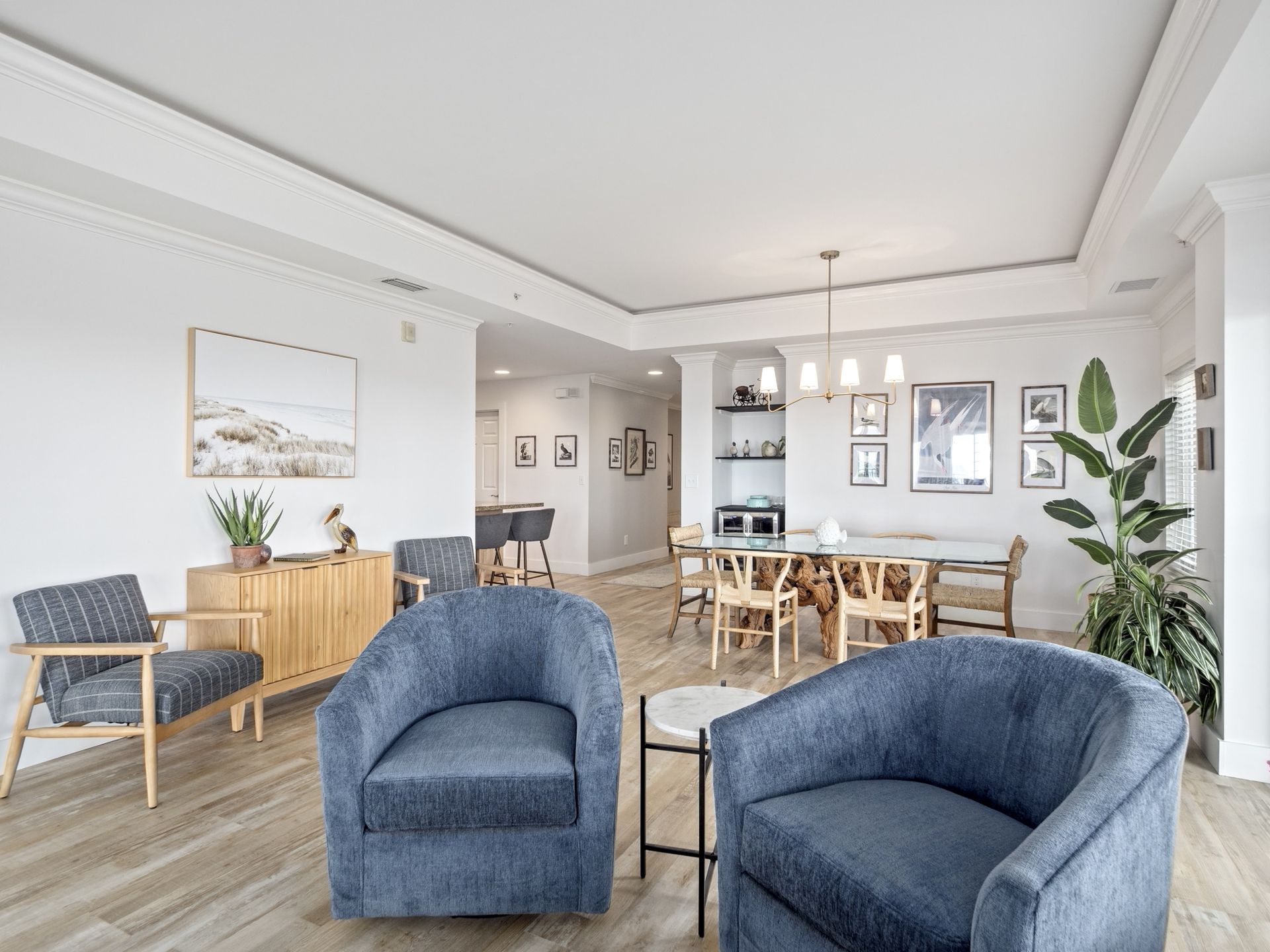 A living room with two blue chairs and a table.