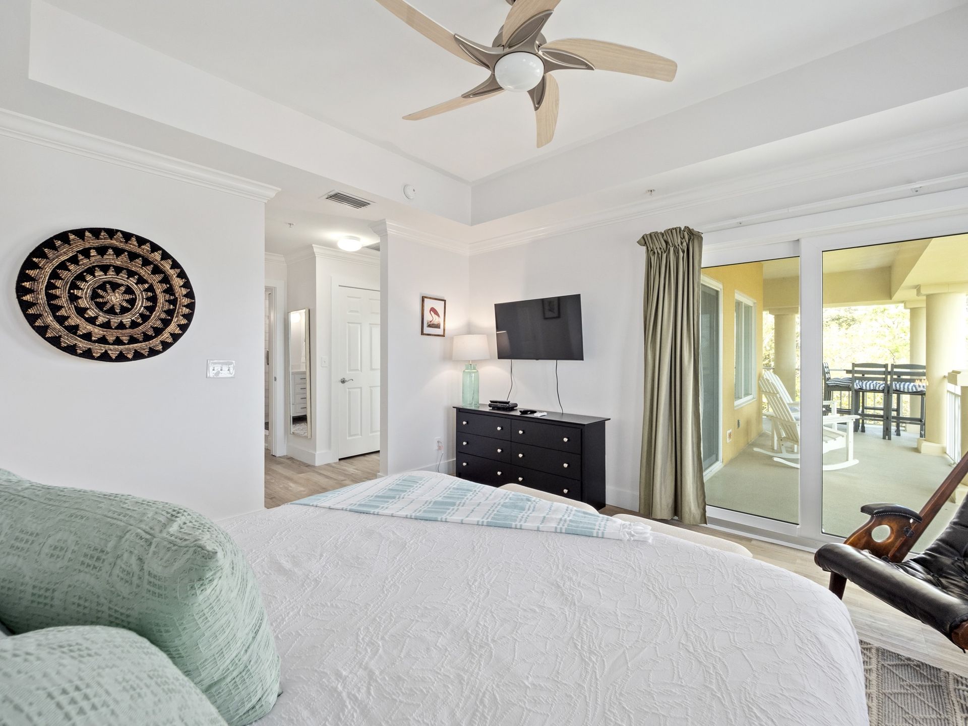A bedroom with a large bed and a ceiling fan
