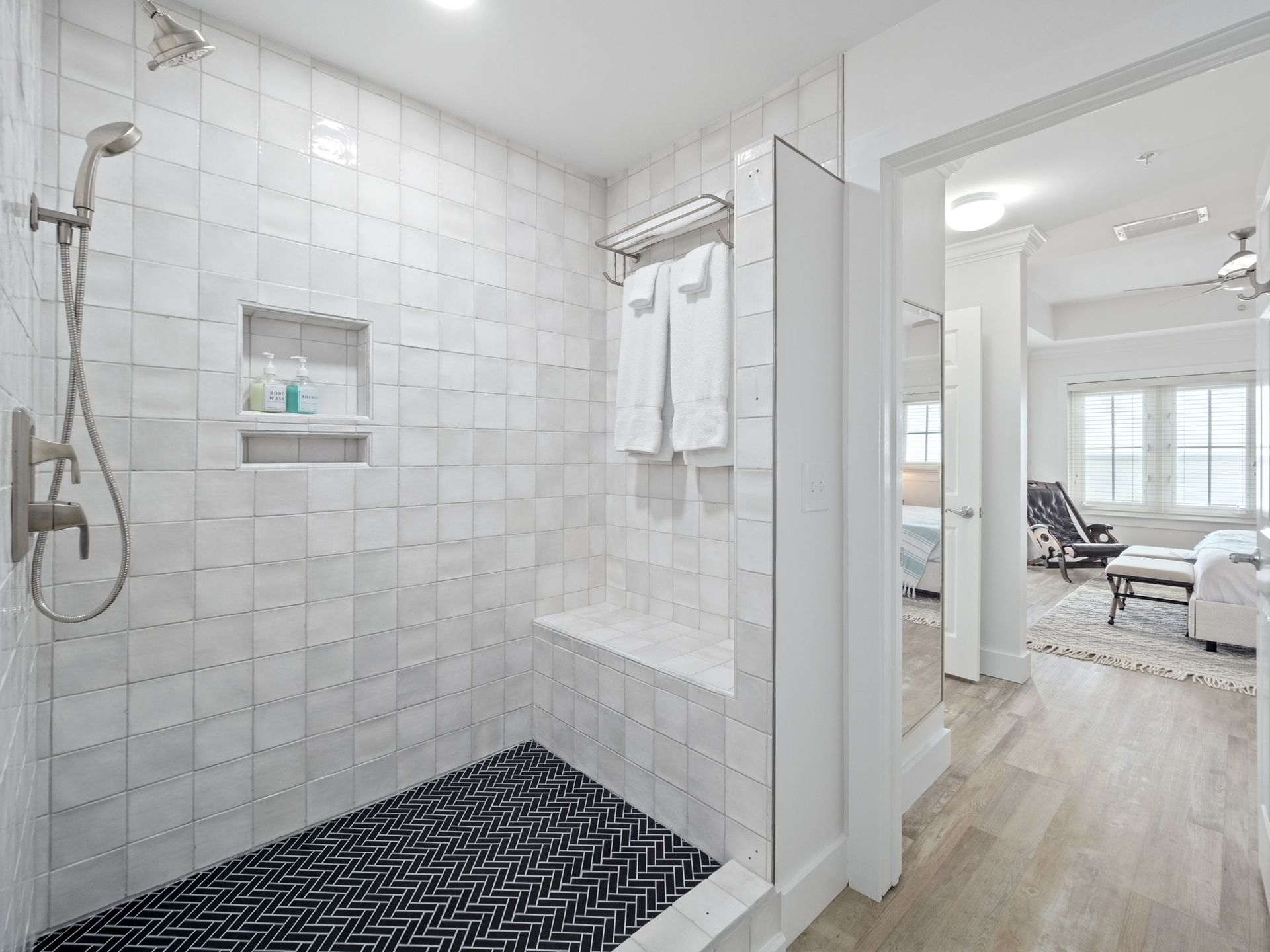 A bathroom with a walk in shower and a bench.