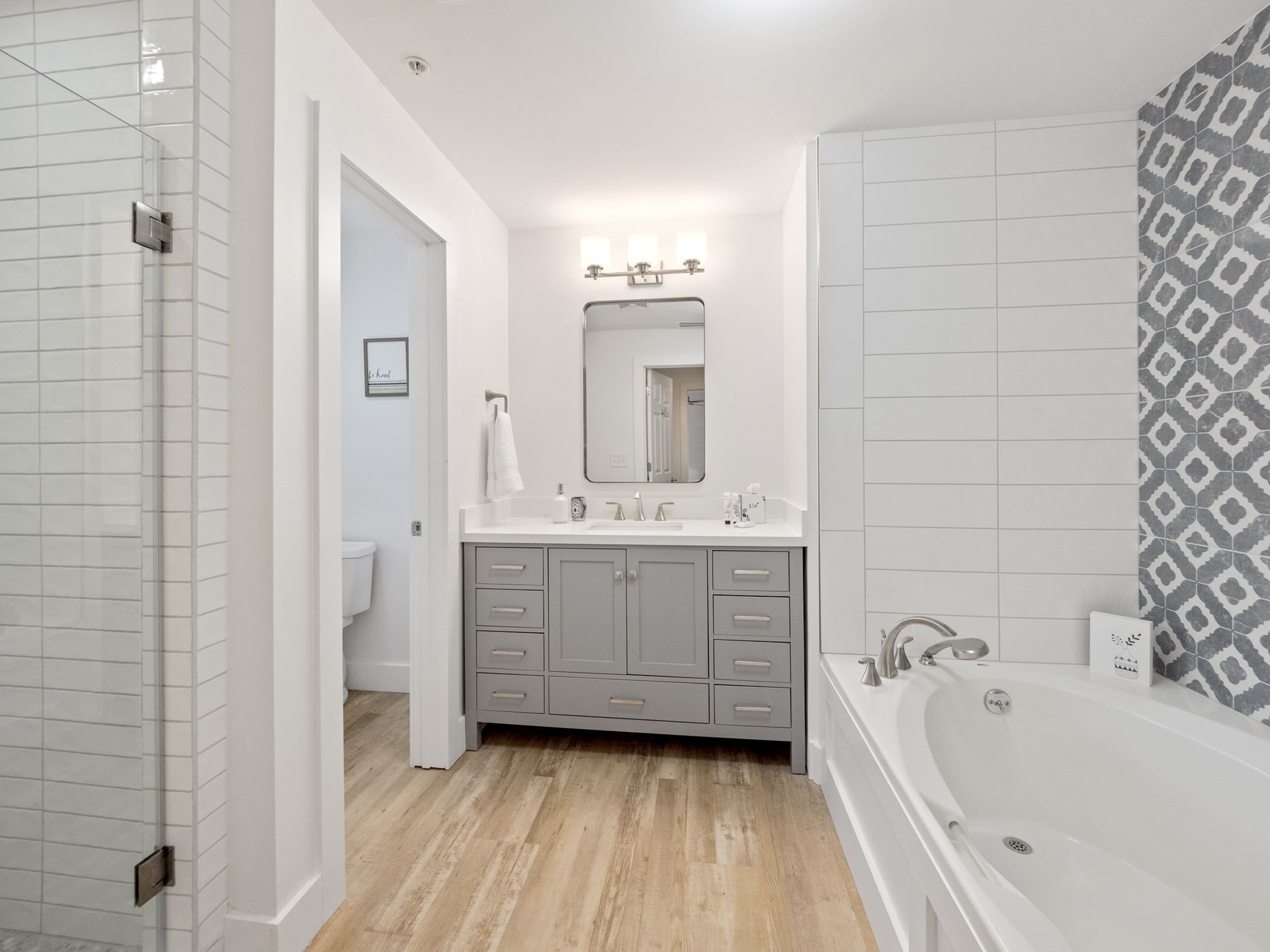 A bathroom with a bathtub , sink , mirror and shower.