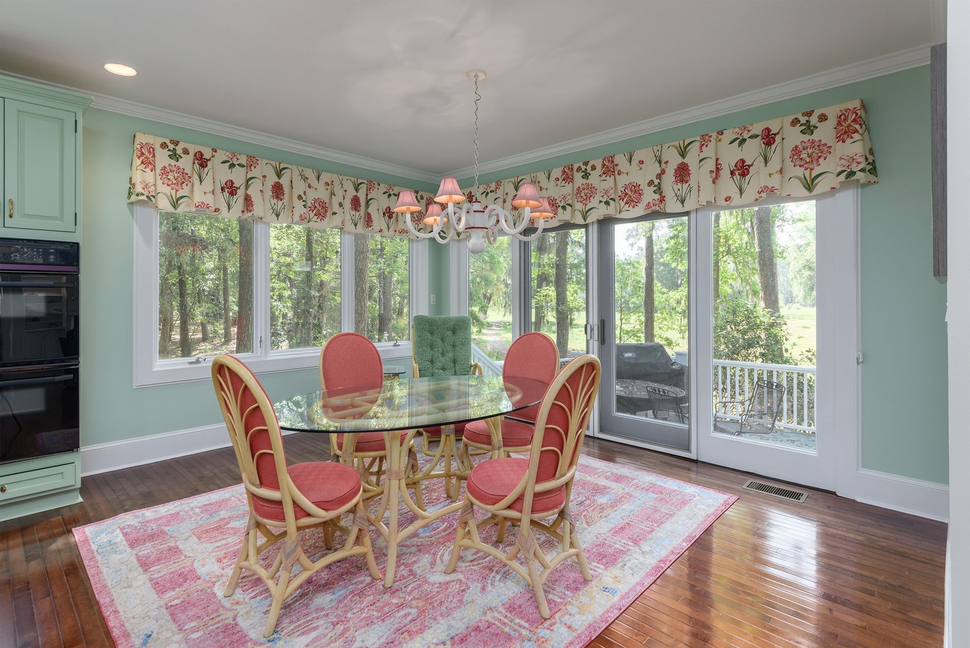 A dining room with a table and chairs and a rug.