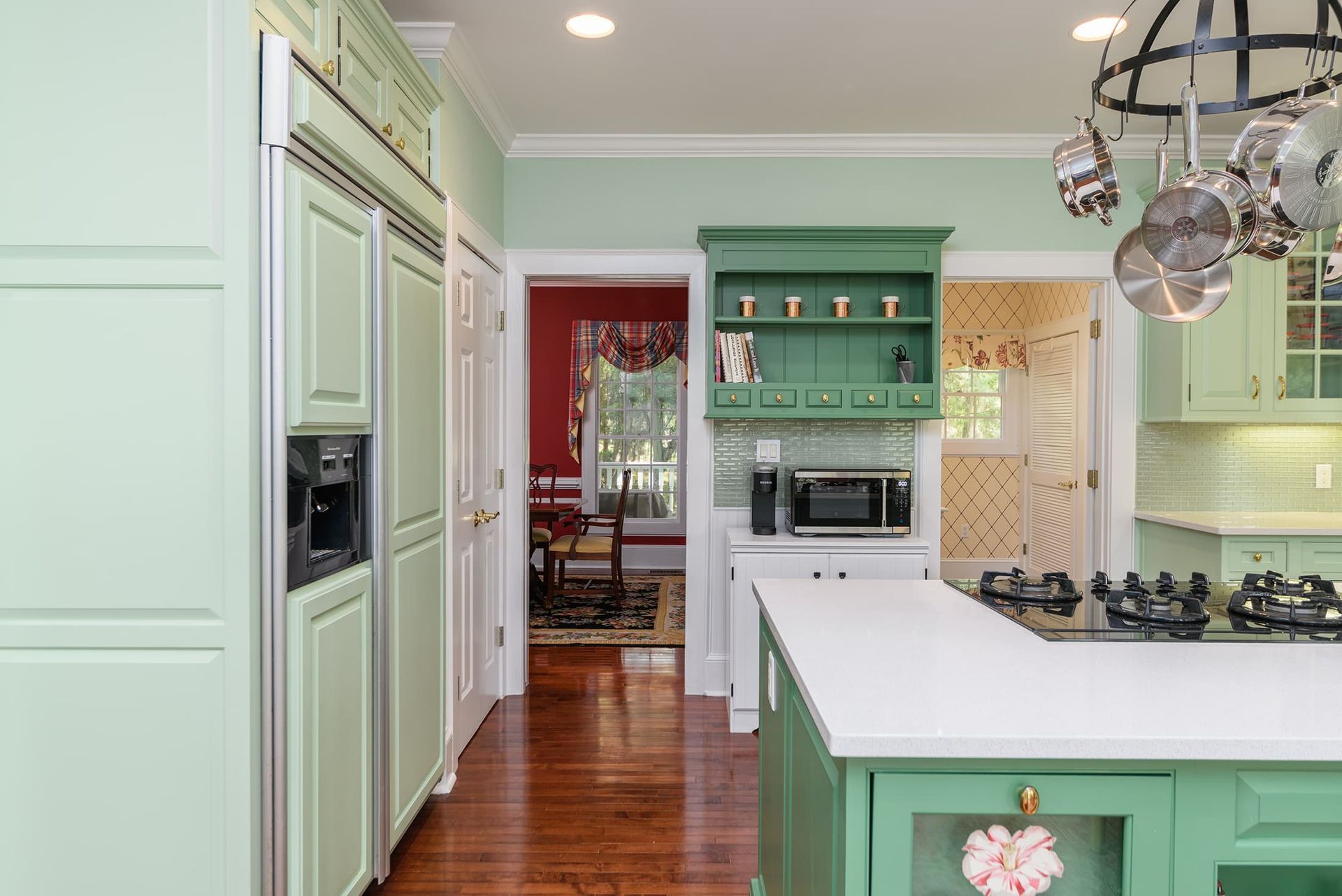 A kitchen with green cabinets and a white counter top.