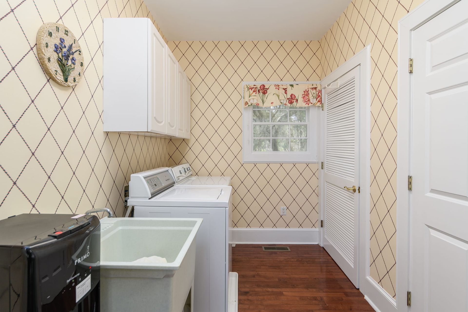 A laundry room with a washer and dryer and a sink.