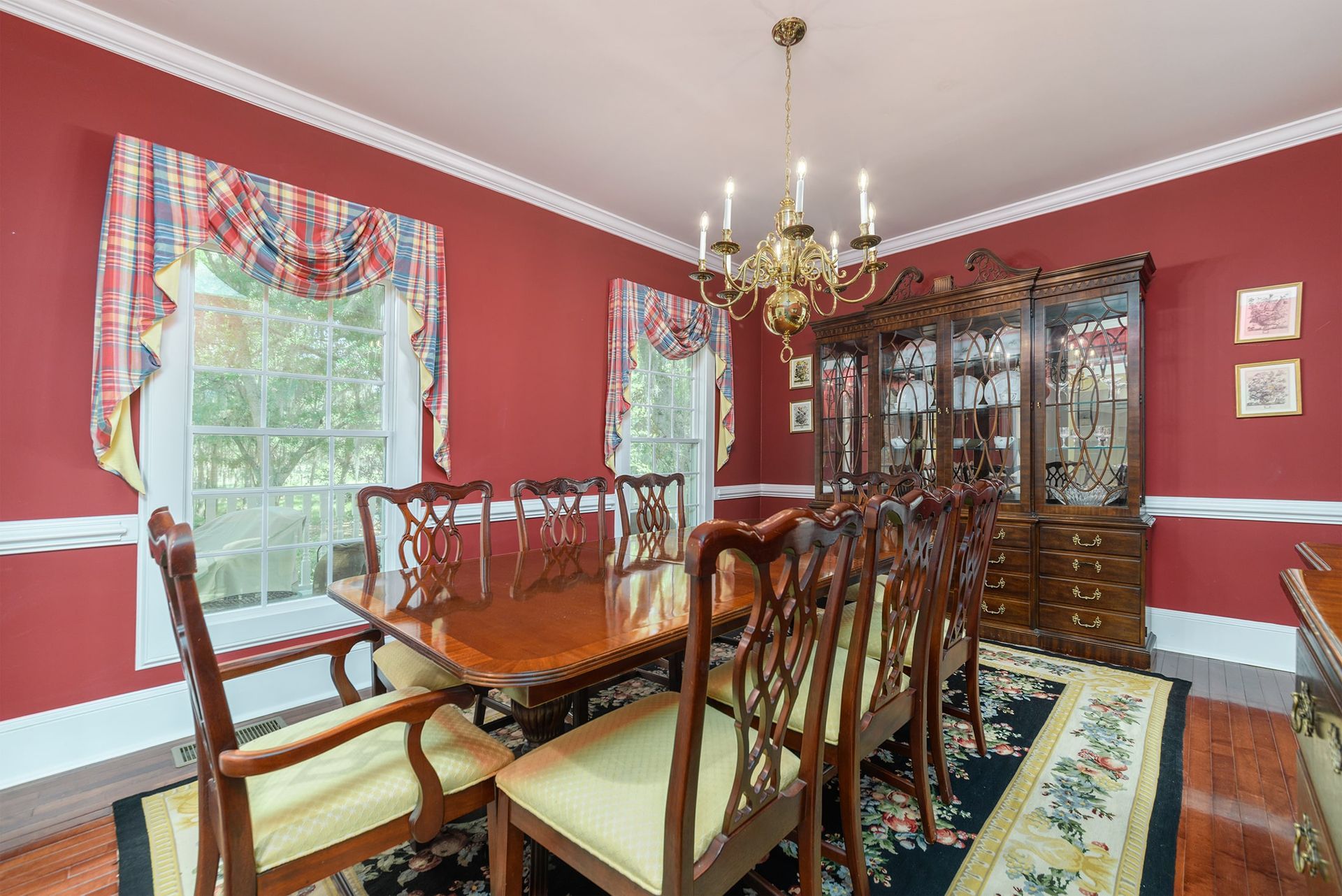 A dining room with a long table and chairs and a chandelier.