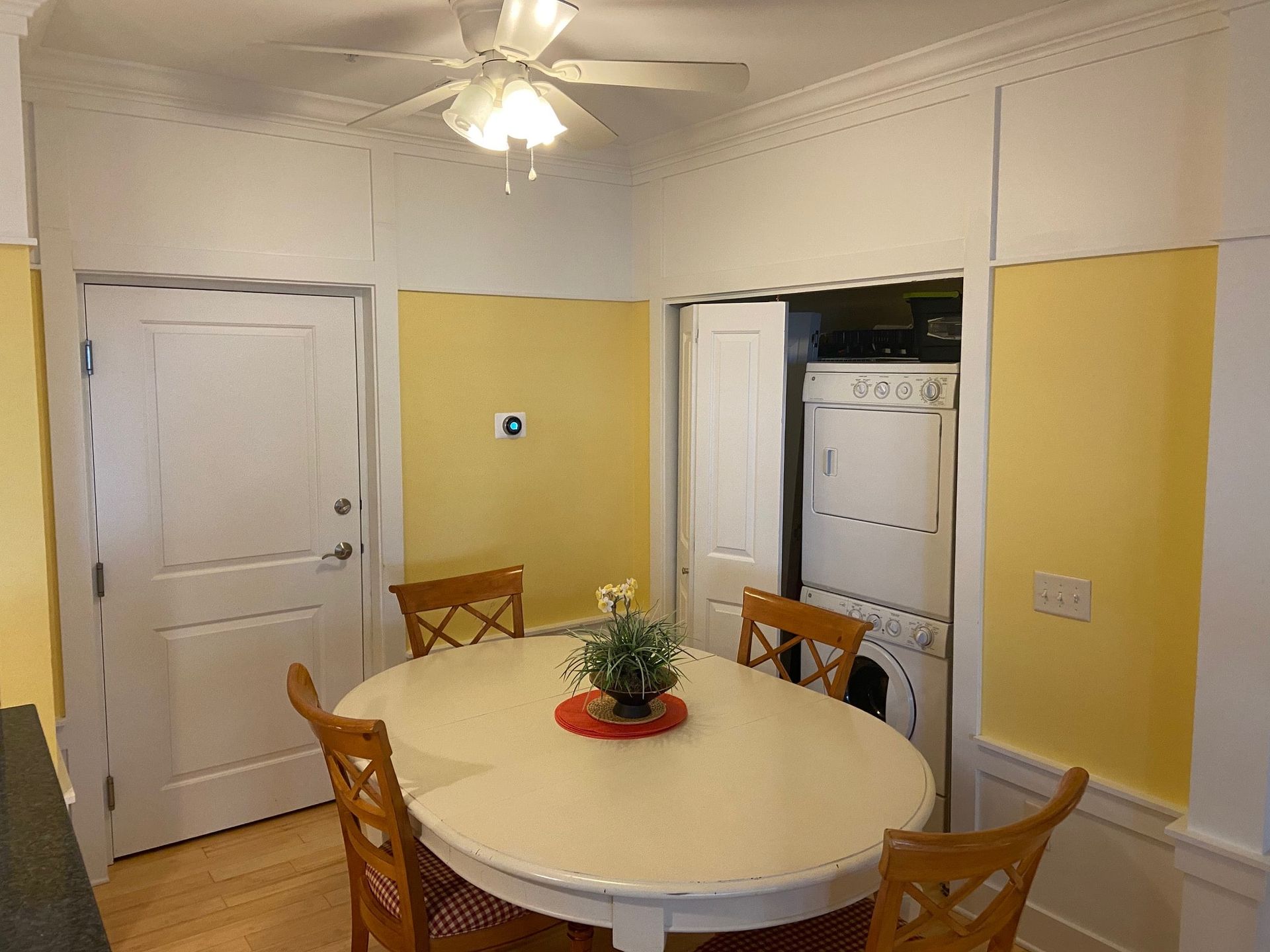 A kitchen with a table and chairs and a ceiling fan