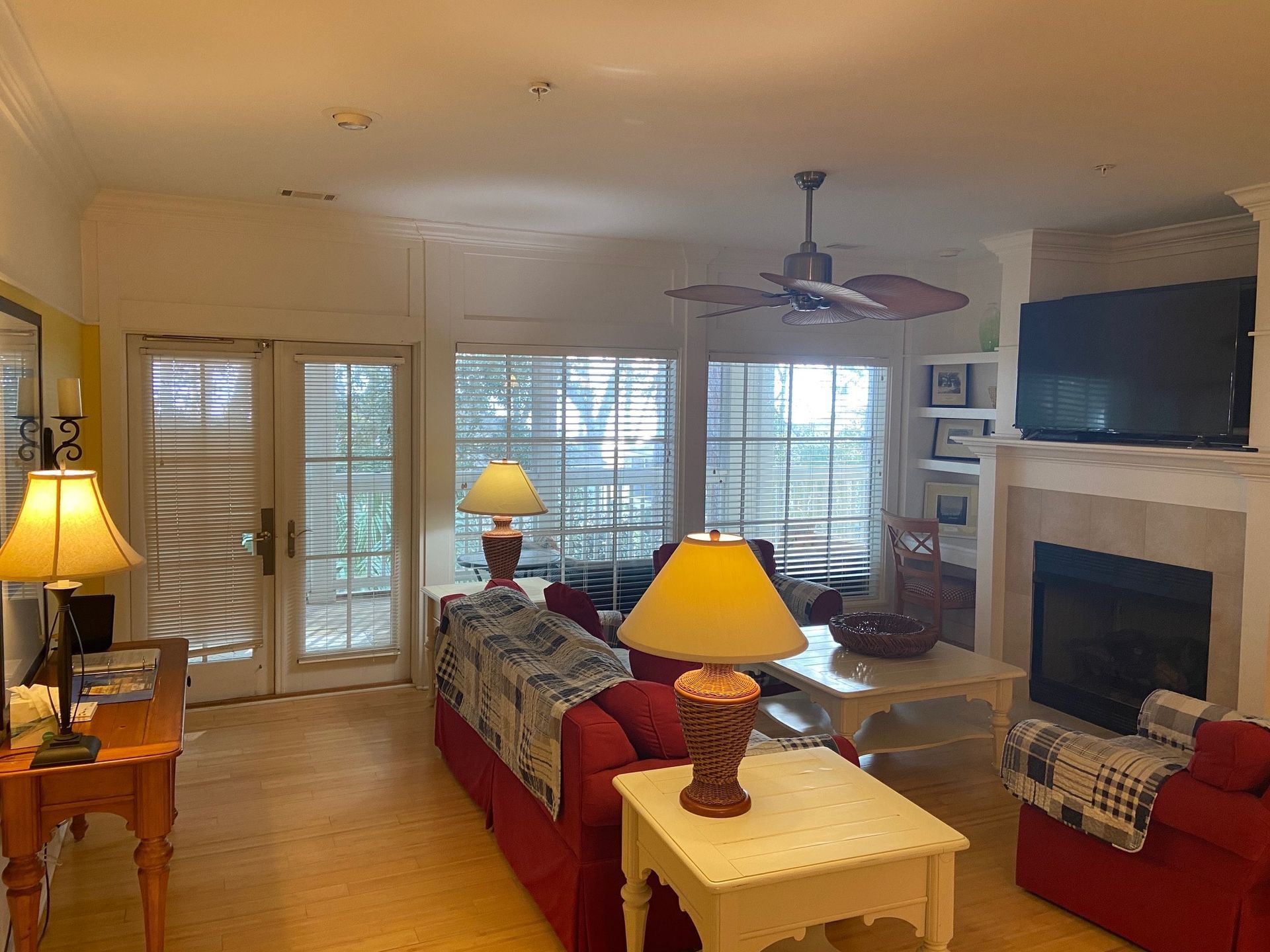 A living room with a fireplace and a ceiling fan