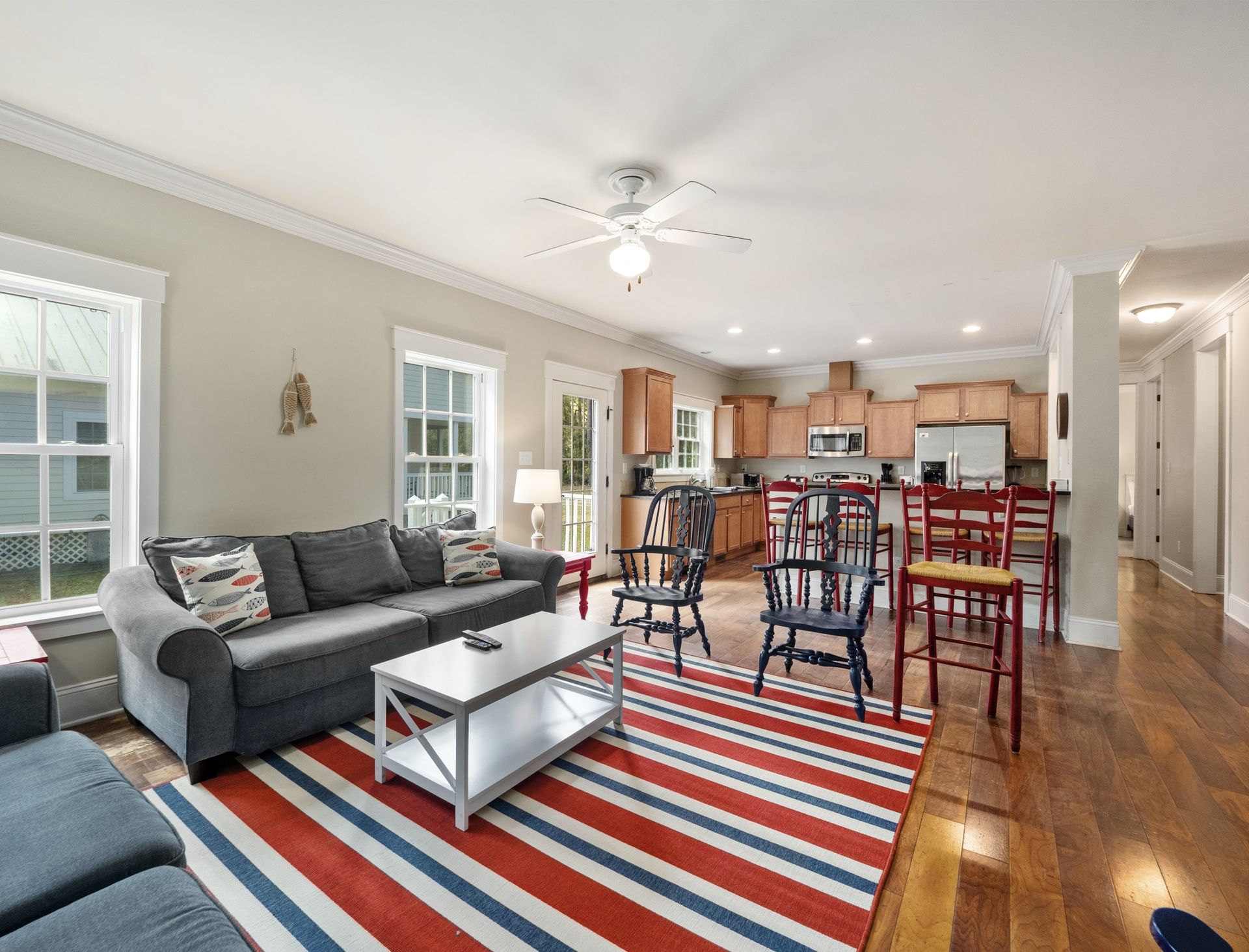 A living room with a couch , coffee table , chairs and a striped rug.