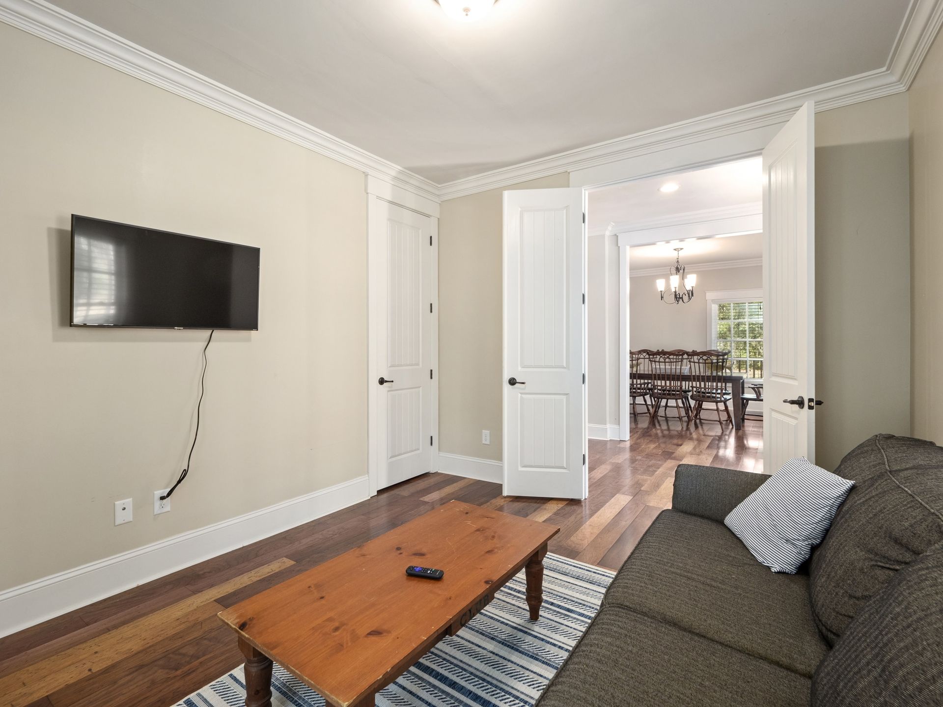 A living room with a couch , coffee table , and flat screen tv.