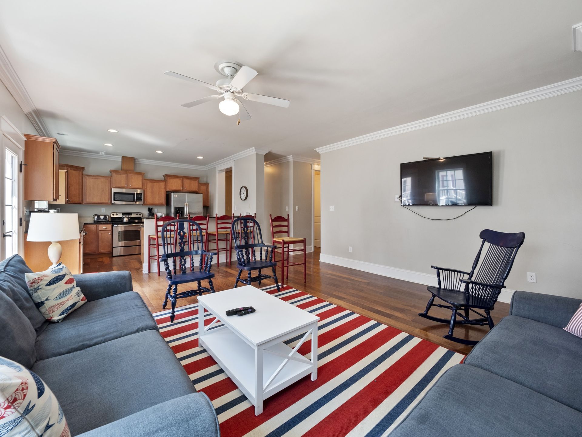 A living room with a couch , chairs , coffee table and television.