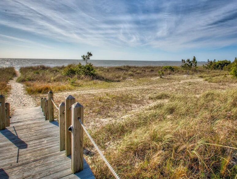 There is a wooden walkway leading to the beach.