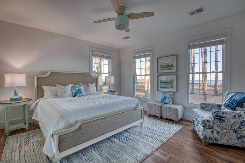 A bedroom with a king size bed , a chair , and a ceiling fan.