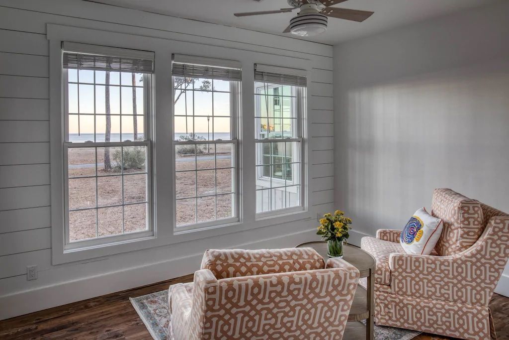 A living room with two chairs and a ceiling fan.