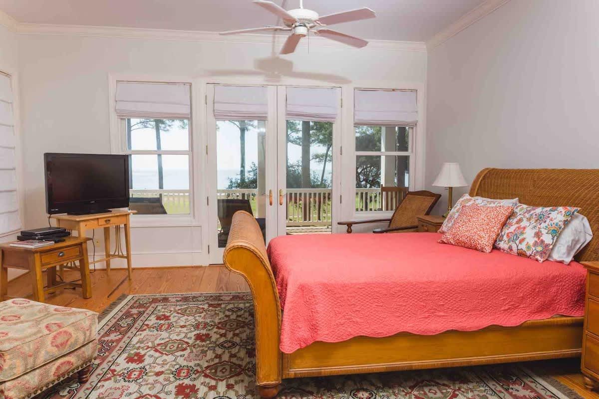 A kitchen with a sliding glass door leading to a porch with trees in the background.