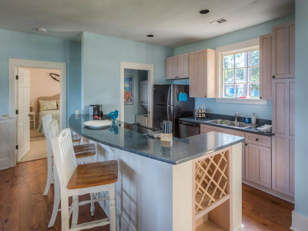 A kitchen with a refrigerator , sink , and bar.