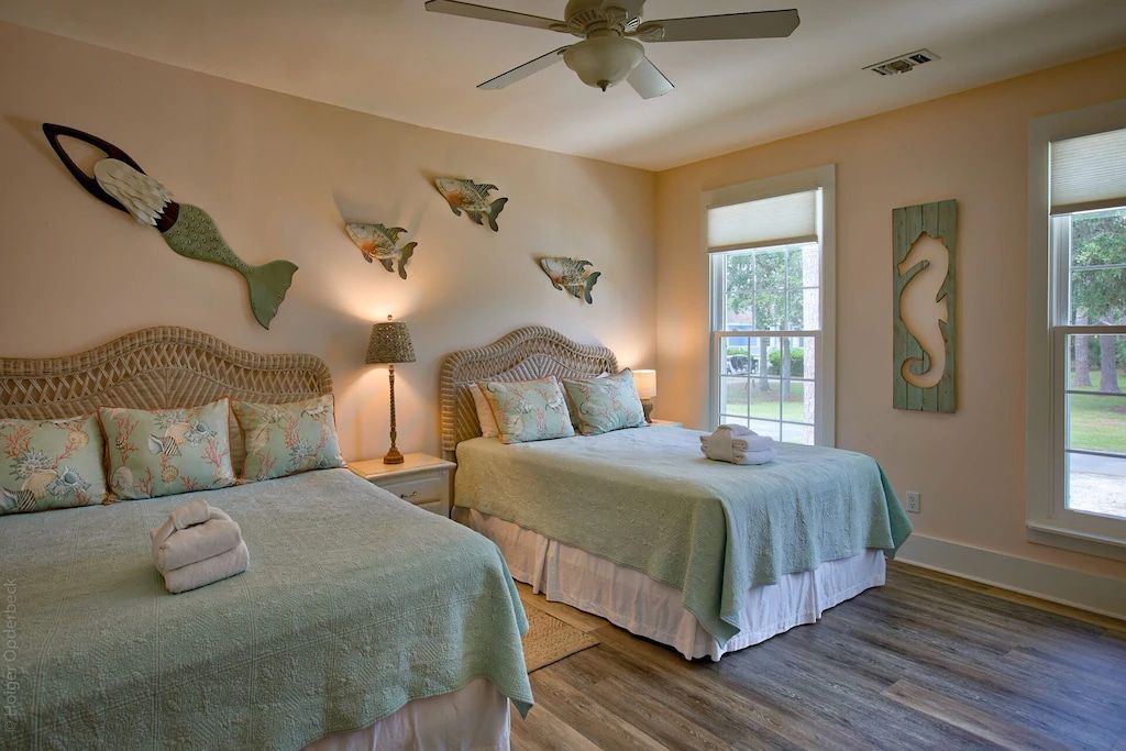 A bedroom with two beds and a ceiling fan.