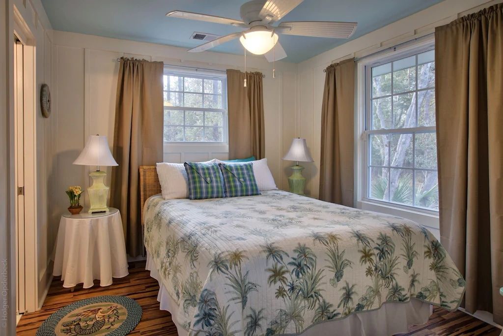 A bedroom with a ceiling fan and a bed