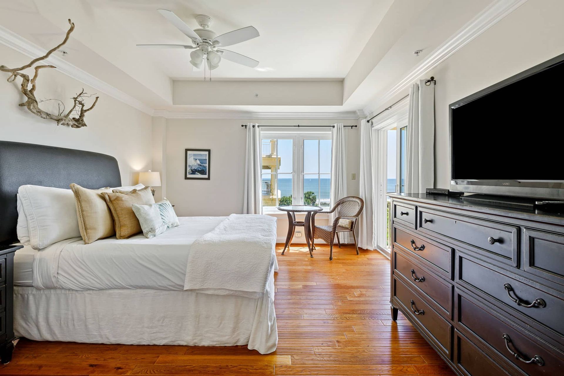 A bedroom with a king size bed , dresser , and television.