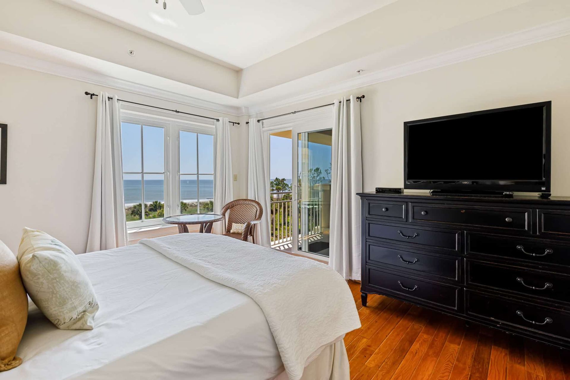 A bedroom with a large bed , dresser , and television.