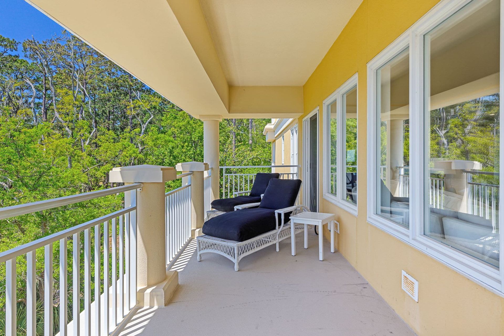 There is a balcony with a chair and a table on it.
