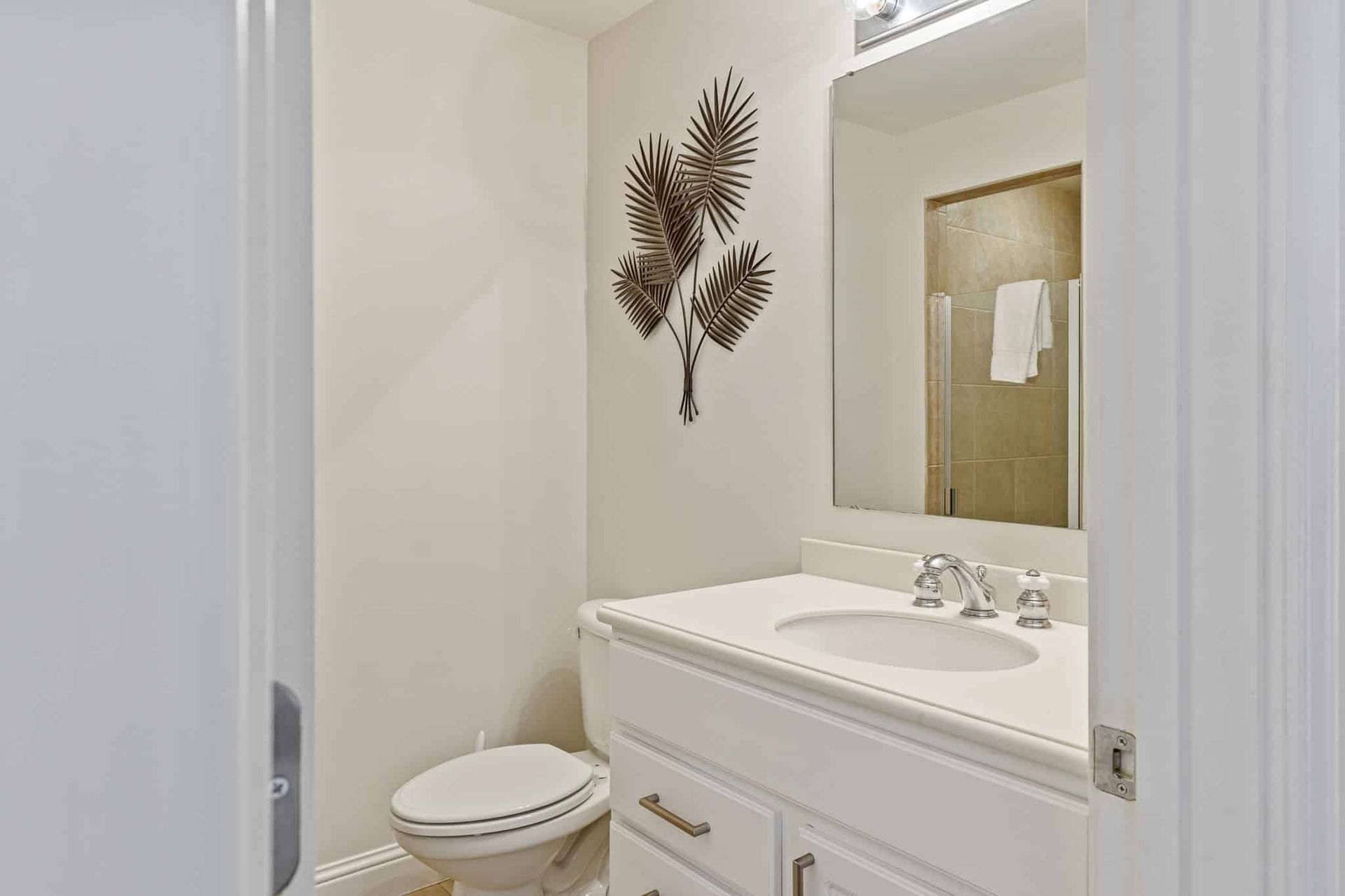 A bathroom with a toilet , sink and mirror.