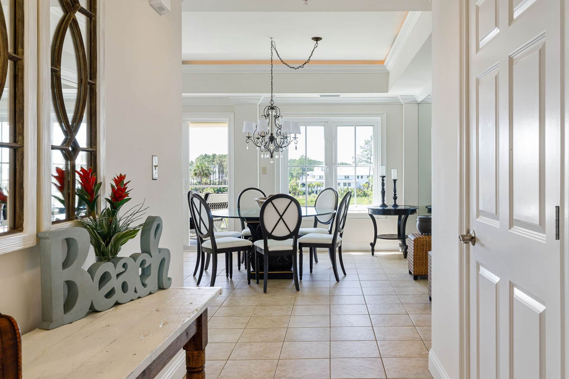 A dining room with a table and chairs and a sign that says beach.