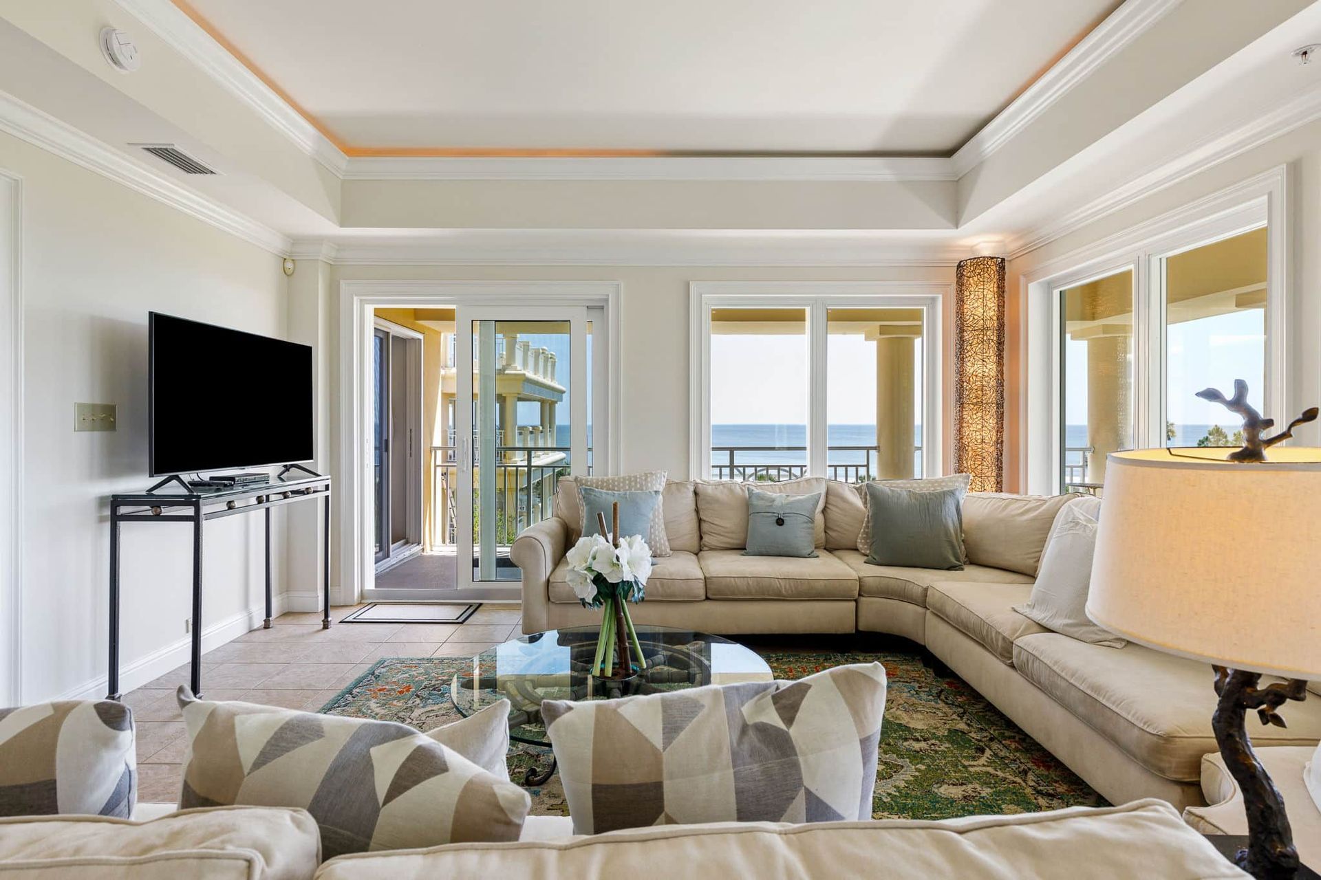 A living room with a large sectional couch and a flat screen tv.