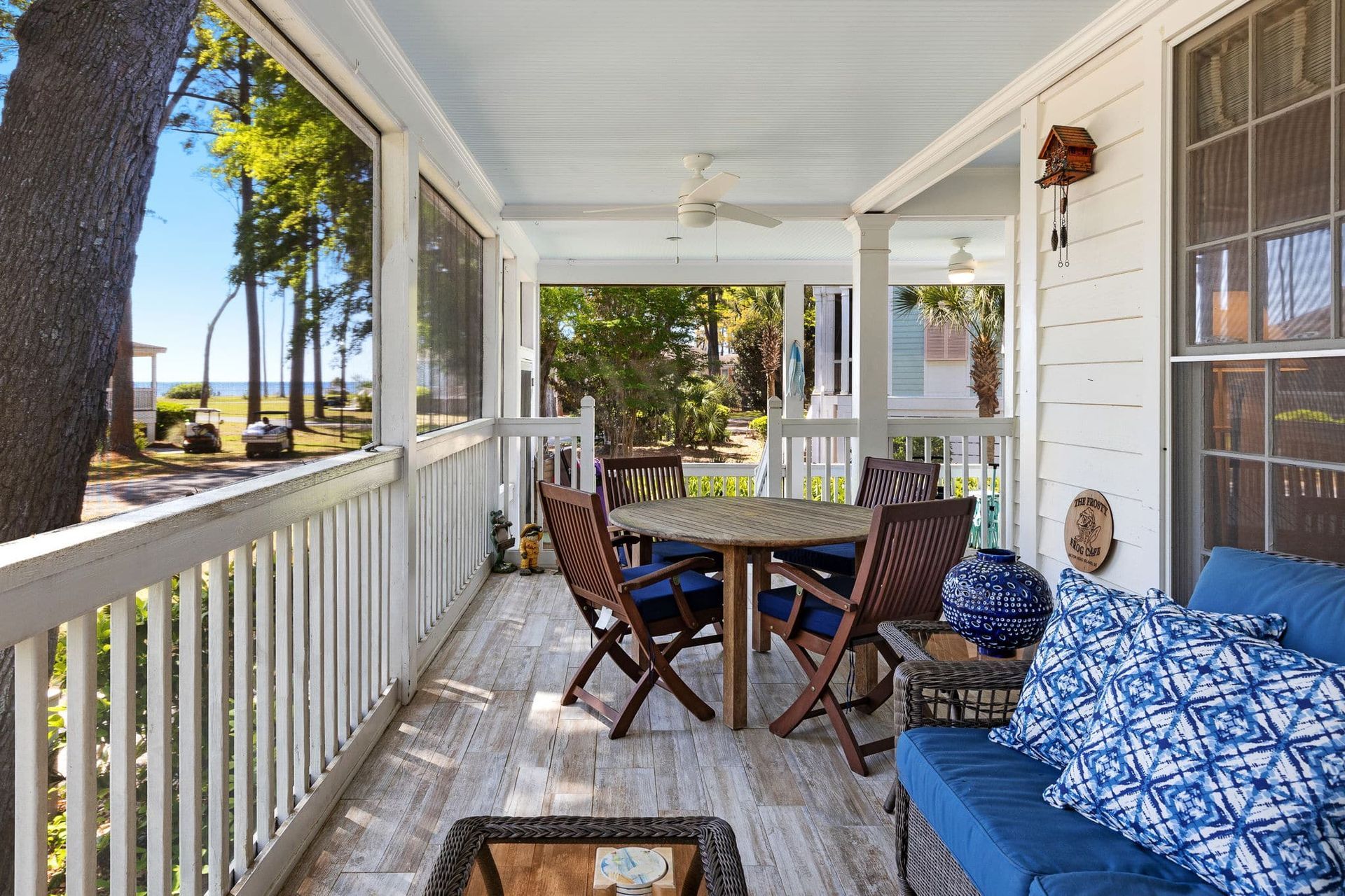 A porch with a table and chairs and a blue couch.