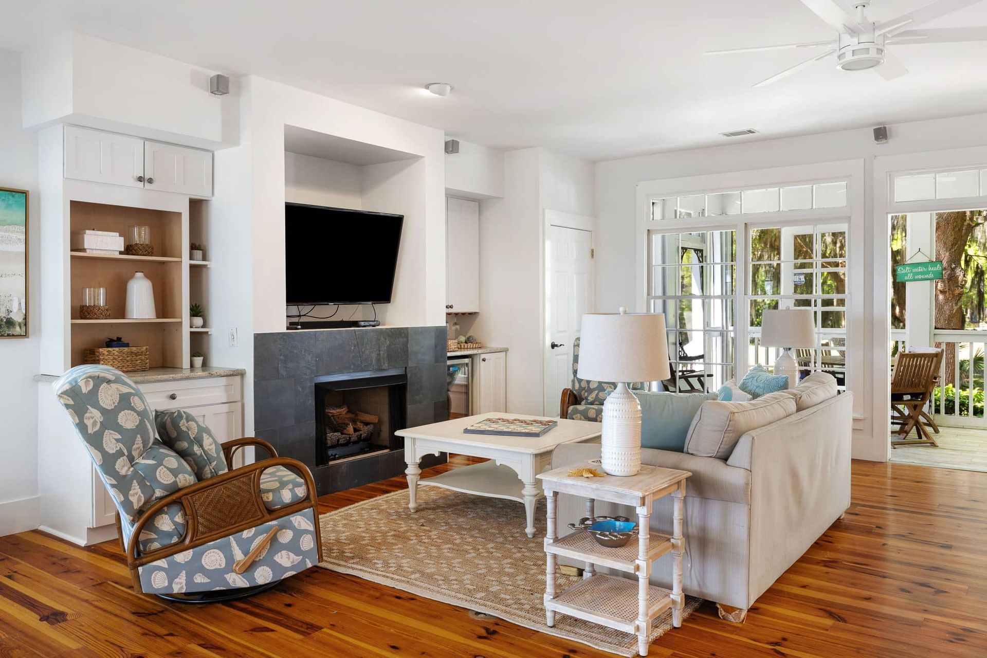 A living room with a couch , chair , fireplace and television.