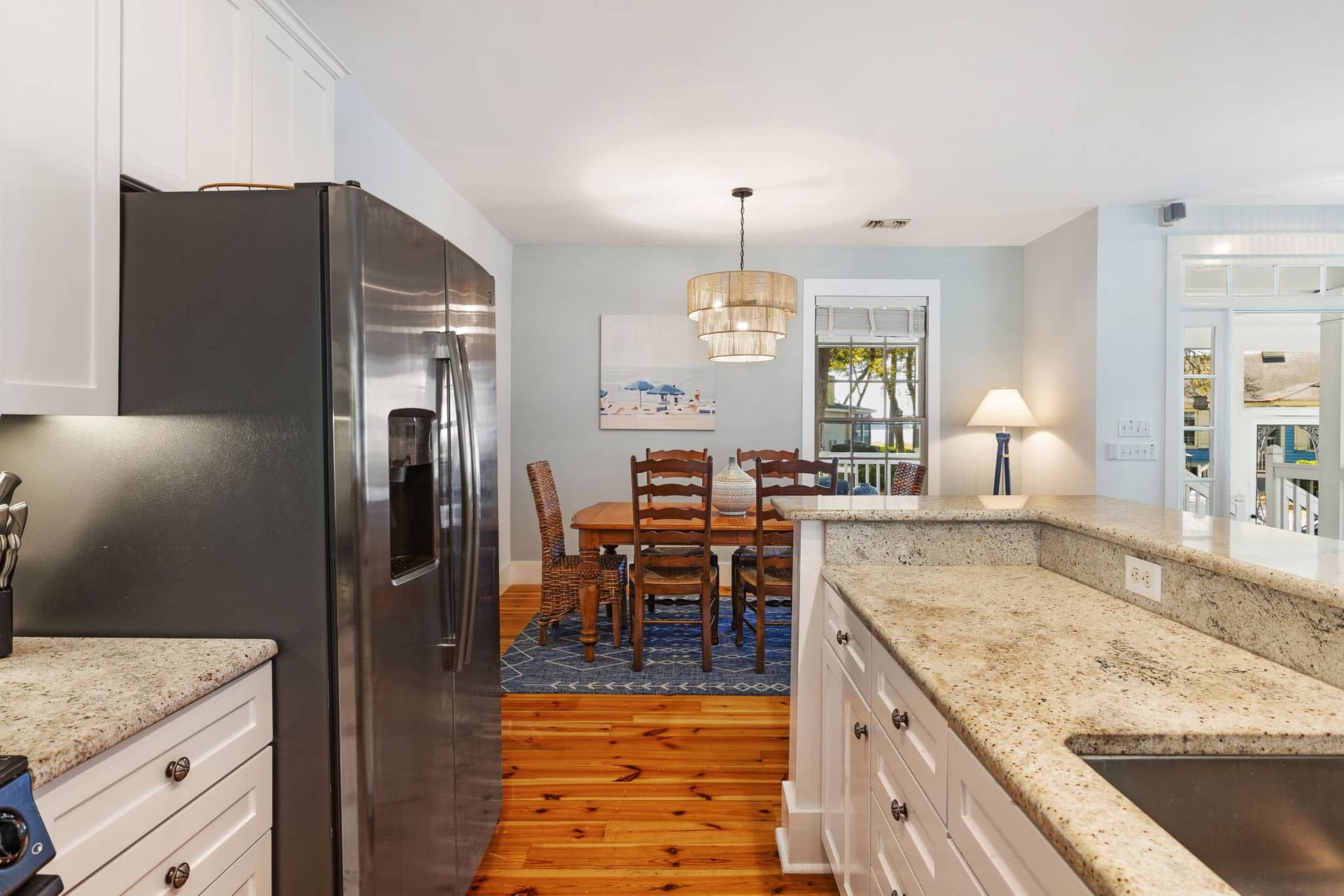 A kitchen with granite counter tops and a stainless steel refrigerator.