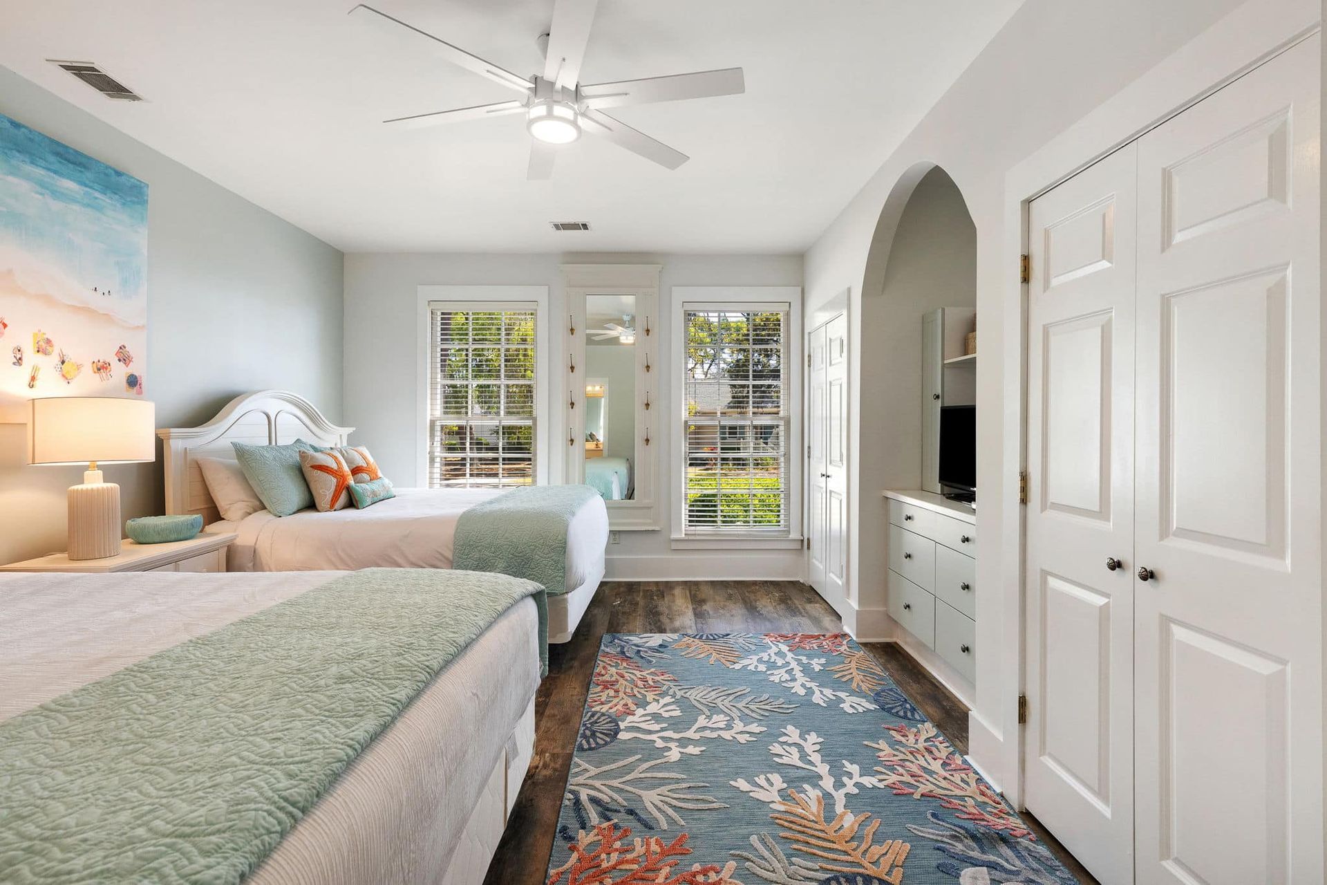 A bedroom with two beds and a ceiling fan.