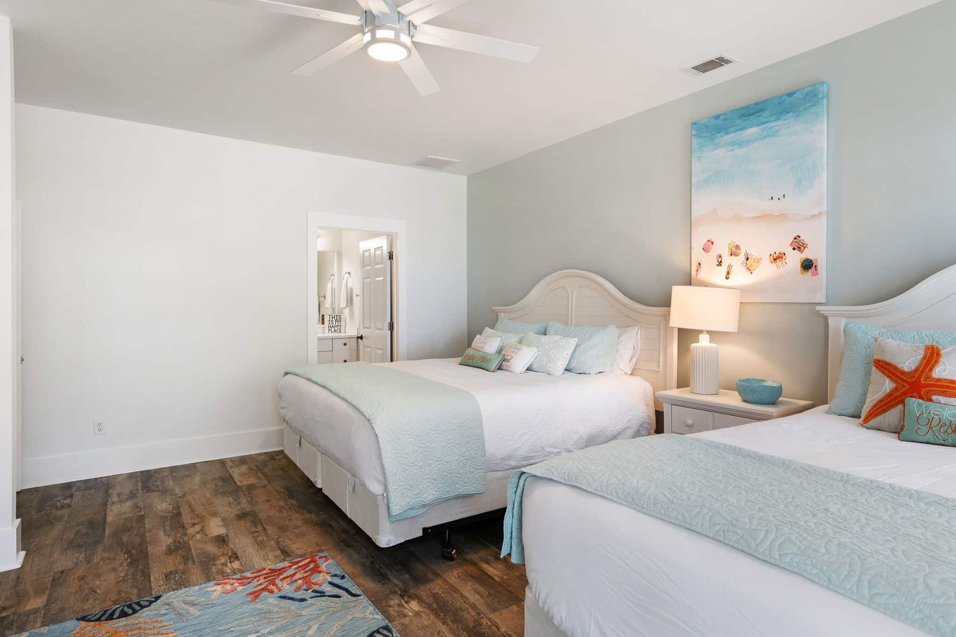 A bedroom with two beds and a ceiling fan.