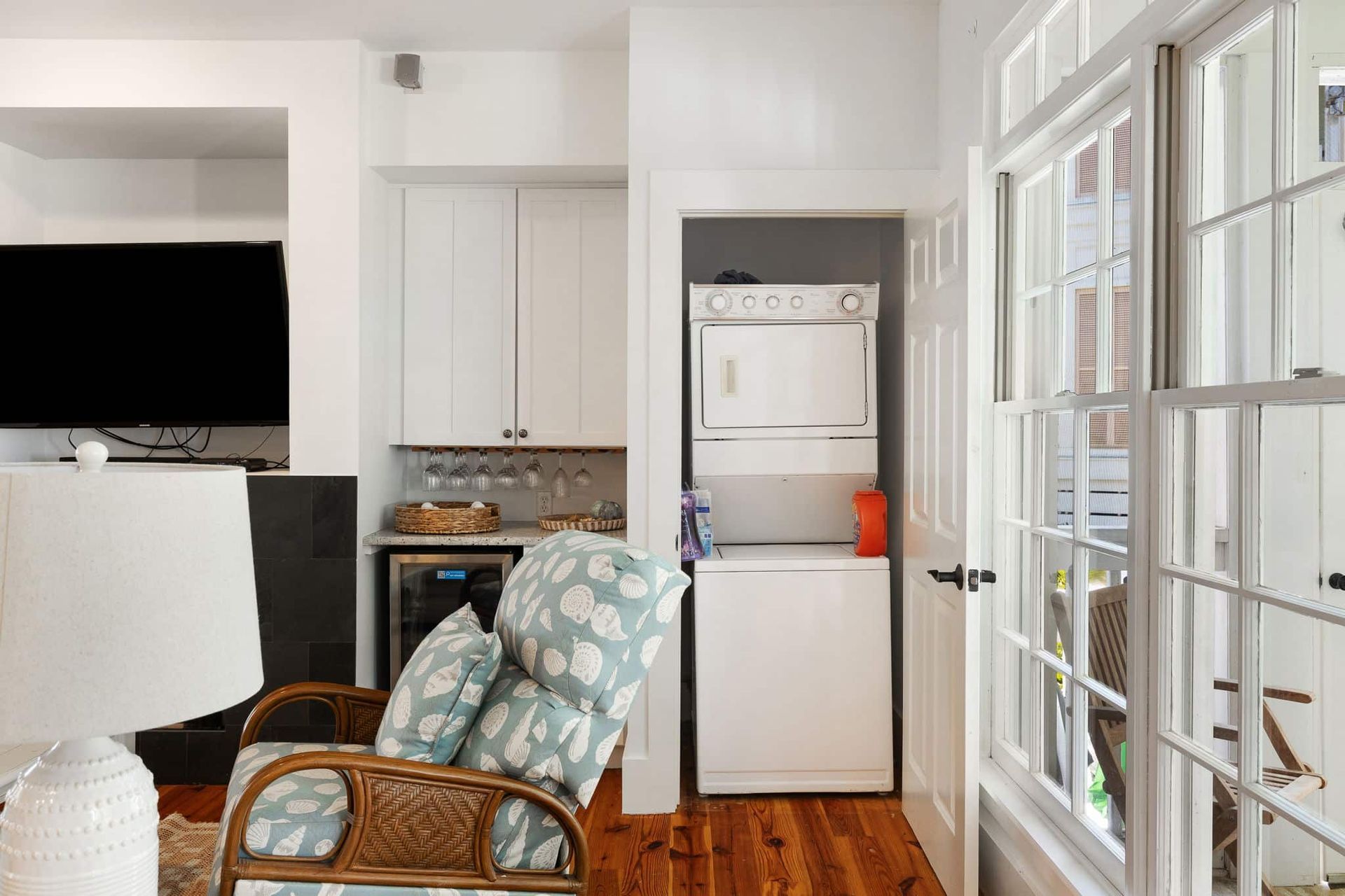 A living room with a washer and dryer stacked on top of each other.