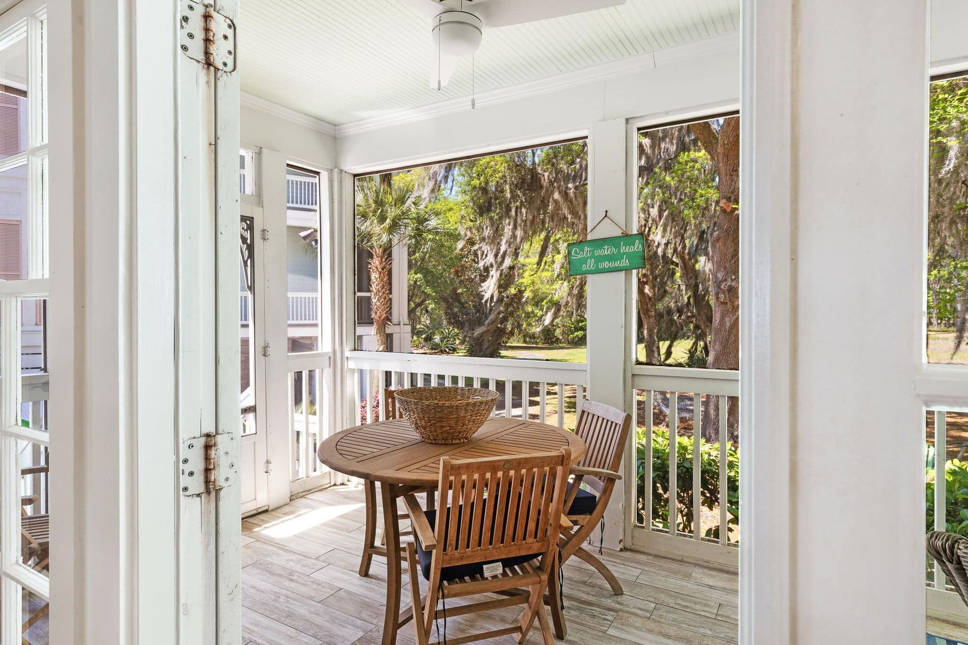 A screened in porch with a table and chairs